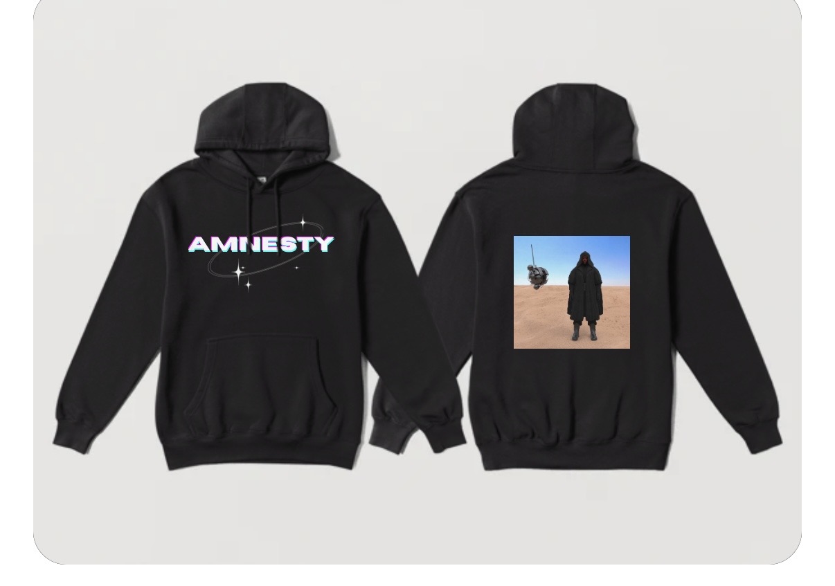 Concept mockup of the AMNESTY hoodie — the front shows a chrome AMNESTY wordmark ringed by a Saturn-style orbit and sparkles; the back shows a square print of a hooded figure standing in a desert beneath a hovering drone